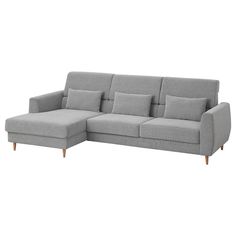 a gray couch with pillows on it and a wooden leg rest in front of the couch