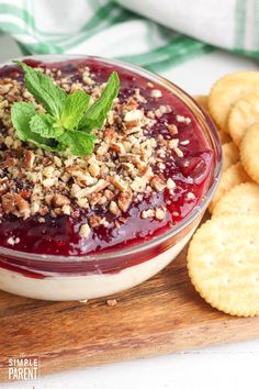 a small bowl filled with fruit and nuts next to crackers