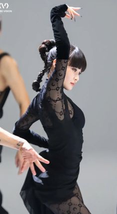 two women in black dresses are doing dance moves with their hands up to the side