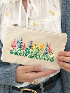 Hand Painted Wildflower Organic Zip Pouch BagThis super gorgeous pouch is made from 100% organic cotton and hand painted (by me!) with solvent free fabric paints, the perfect eco friendly gift!Due to making process each piece is completely unique! None will look exactly the same!Each pouch is made from sustainably sourced organic cotton and comes with a metal zip so you can keep all your small belongings safe and secure. Plus you can guarantee that your pouch will be the only one of its kind as Pencil Pouch Ideas, Crochet Pencil Pouch, Painted Canvas Bags, Pouch Ideas, Crochet Pencil, Fabric Painting Techniques, Pouch Diy, Canvas Purse, Pen Pouch