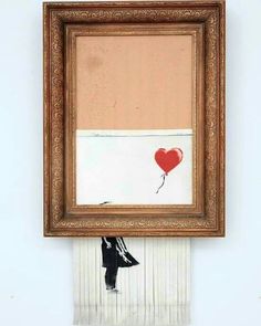 a painting hanging on the wall with a red balloon attached to it's frame