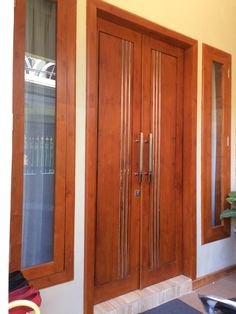 two wooden doors in front of a yellow wall