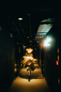 a woman walking down a dark hallway with lights on