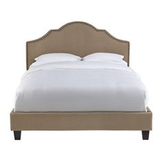 an upholstered bed with white sheets and beige linens on the headboard