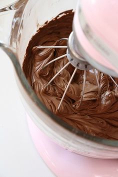 a mixer filled with chocolate frosting on top of a counter