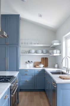 a kitchen with blue cabinets and white counter tops