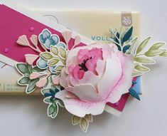 a close up of a flower on a piece of paper next to a card holder