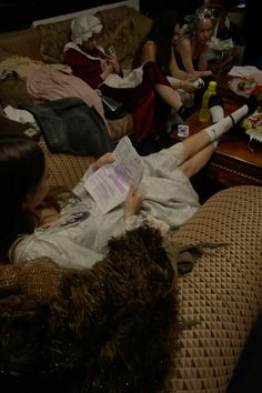 people are sitting on couches in the living room and one person is reading a paper