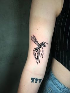 a woman with a bee tattoo on her arm