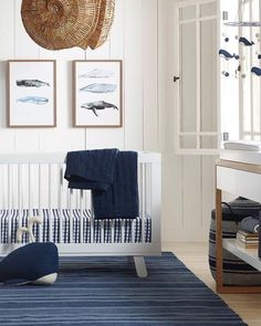 a baby's room with blue and white decor, including a crib bed