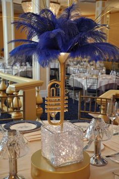 a table topped with a musical instrument and blue feathers