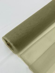 a roll of sheer fabric on a white surface