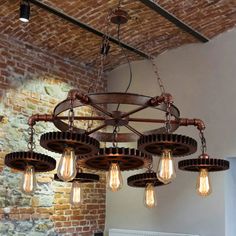 a chandelier hanging from the ceiling in a room with brick walls and exposed ceilings