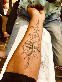 a man with a compass tattoo on his arm