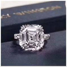 an old - fashioned diamond ring sits on top of a book