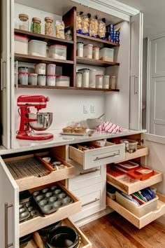 an organized kitchen with lots of drawers and items in the drawer area, including a mixer