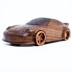 a toy car made out of wood on a white background