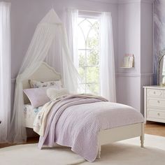 a bedroom with purple walls and white furniture