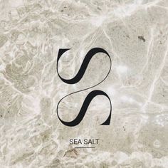 the logo for sea salt is shown on a marble background with black letters and swirls