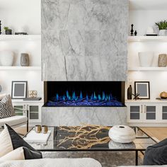 a living room with white walls and a large fireplace that has blue flames on it