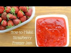 a bowl of strawberries next to a container of strawberry jam