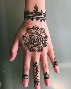 a woman's hand with henna tattoos on it