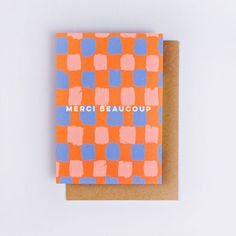 an orange and blue greeting card with the words merci beaucoup on it