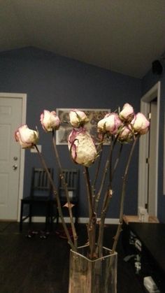 a vase filled with flowers on top of a wooden table