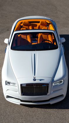 the front end of a white car with orange seats