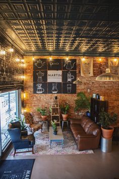 a living room filled with furniture and lots of lights hanging from the ceiling next to a brick wall