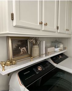 a white stove top oven sitting inside of a kitchen next to a painting on the wall