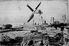 an old black and white photo of a windmill