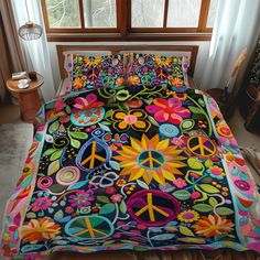 a bed covered in colorful bedspread with peace signs and flowers on the comforter