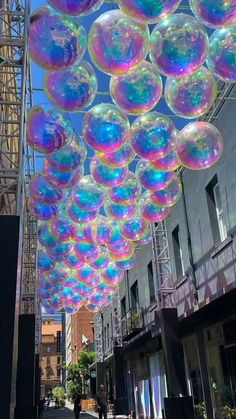 many soap bubbles are floating in the air above a street lined with buildings and people