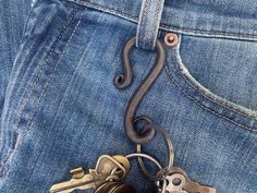 two keys are attached to the back pocket of a pair of jeans with a keychain