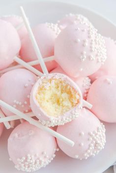 pink cake pops with white sprinkles are arranged on a plate and ready to be eaten