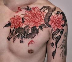 a close up of a person with a tattoo on his chest and flowers in the background