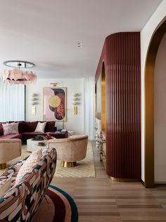 a living room filled with lots of furniture next to a tall red columned wall