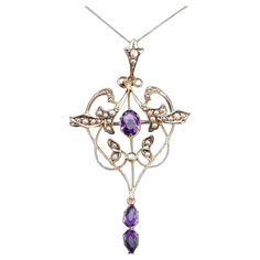 We are delighted to offer this elegant antique Edwardian art nouveau pendant necklace made c.1905. The goldwork is beautifully crafted with a naturalistic art nouveau design of scrolled foliate motifs forming an almost heart-shaped design. The pendant features two lovely faceted amethysts with a rich and regal purple hue. Further embellishments of fine seed pearls accentuate the overall appearance and create a contrast to the purple and gold tones. The bottom drop amethyst and the bail (top) mov Luxury Art Nouveau Formal Necklace, Art Nouveau Pendant Necklace, Art Nouveau Pendant Jewelry With Intricate Design, Art Nouveau Yellow Gold Gemstone Necklaces, Stile Art, Luxury Art Nouveau Pearl Pendant Necklace, Edwardian Art, Art Nouveau Pendant, Velvet Interiors