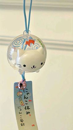 an ornament with a cat on it hanging from a blue ribbon and tag