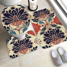 two bathroom rugs on the floor next to a toilet