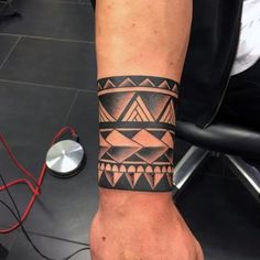 a man's arm with a tattoo on it that has an arrow and triangles