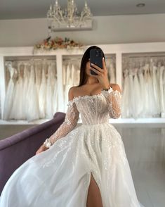 a woman is taking a selfie in her wedding dress while she sits on a couch