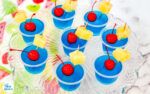 blue cups filled with fruit on top of a table