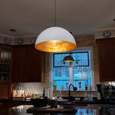 a kitchen with an island and lights hanging from the ceiling