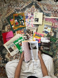 a person laying on top of a bed covered in books