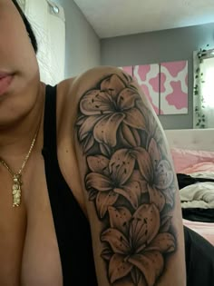 a woman with a flower tattoo on her arm and shoulder is looking at the camera