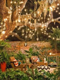 an outdoor seating area is decorated with lights and potted plants