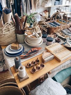 the table is covered with baskets, plates and other crafting supplies for sale at the market