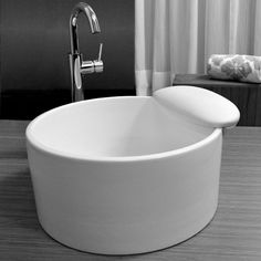 a large white bowl sitting on top of a wooden table